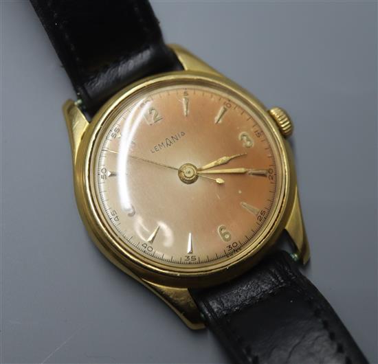 A gentlemans 750 yellow metal Lemania manual wind wrist watch, on associated black leather strap.